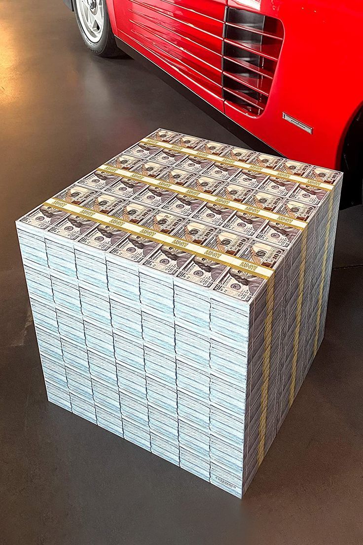 stacks of money sitting next to a red sports car