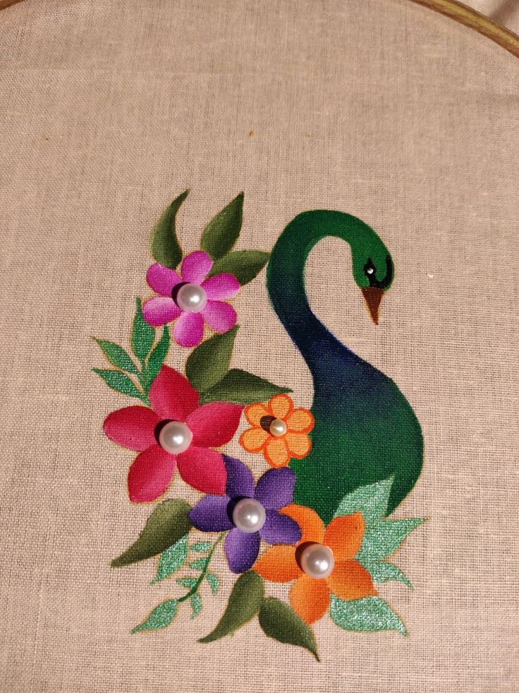 an embroidered peacock with flowers and pearls on it