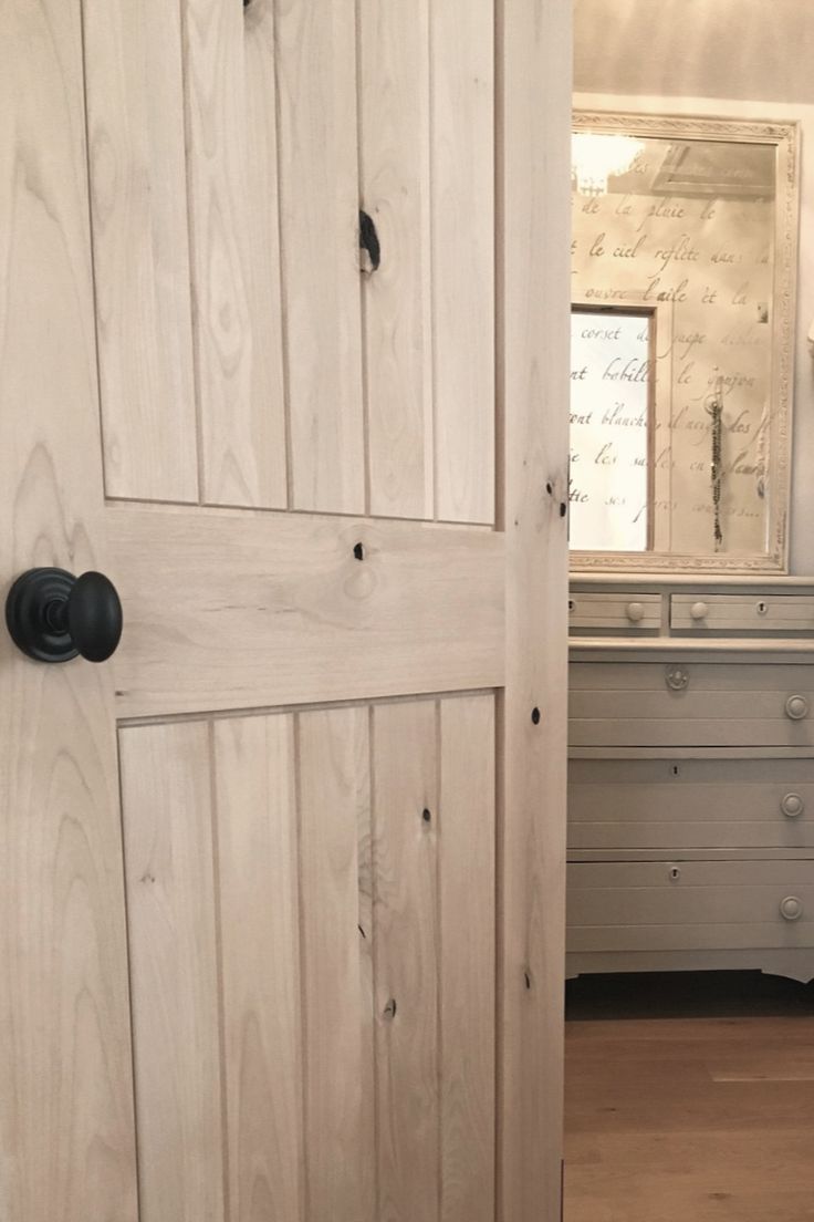 an open door leading to a bedroom with drawers and dressers in the background on a wooden floor