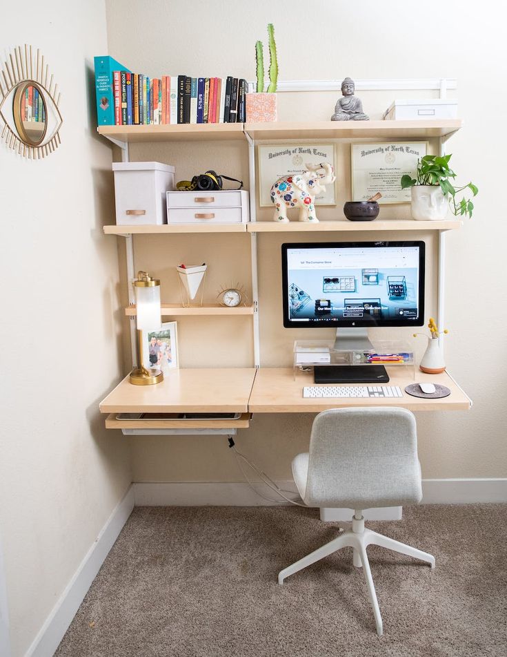 a desk with a computer on top of it in front of a bookshelf