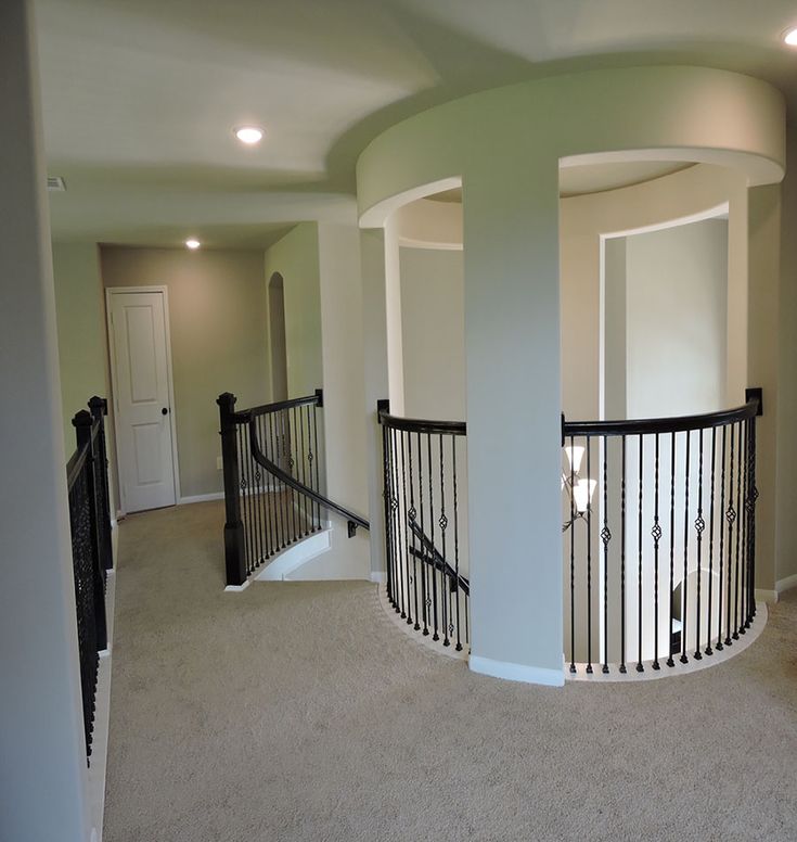 an empty room with two balconies and railings