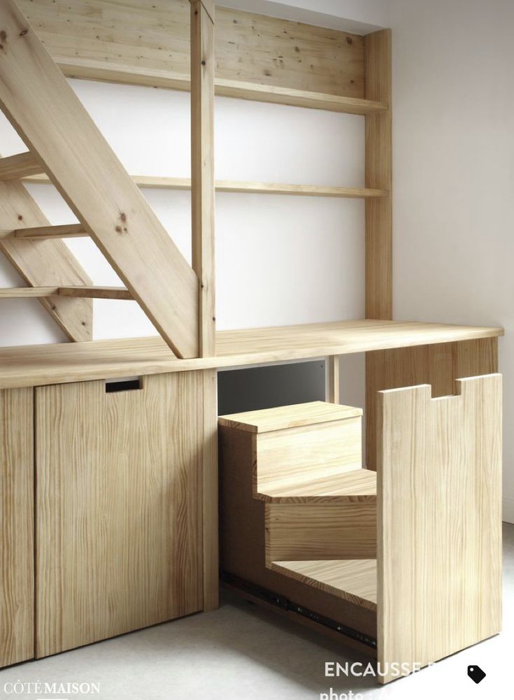 an open book shelf with stairs in the middle and shelves below it that are made out of wood