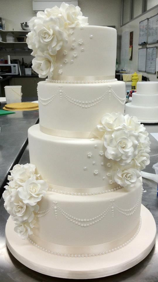 a three tiered cake with white flowers on it