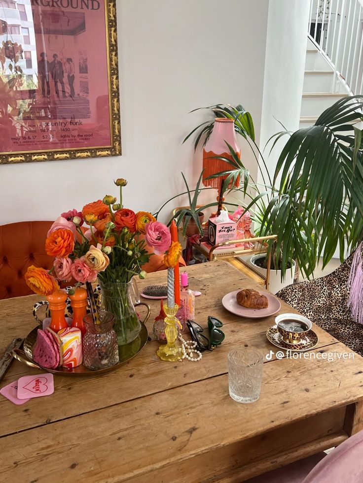 a wooden table topped with lots of different types of food and flowers on top of it