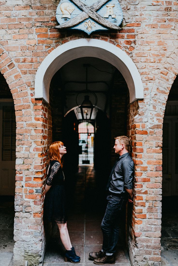 a man and woman are standing in an archway