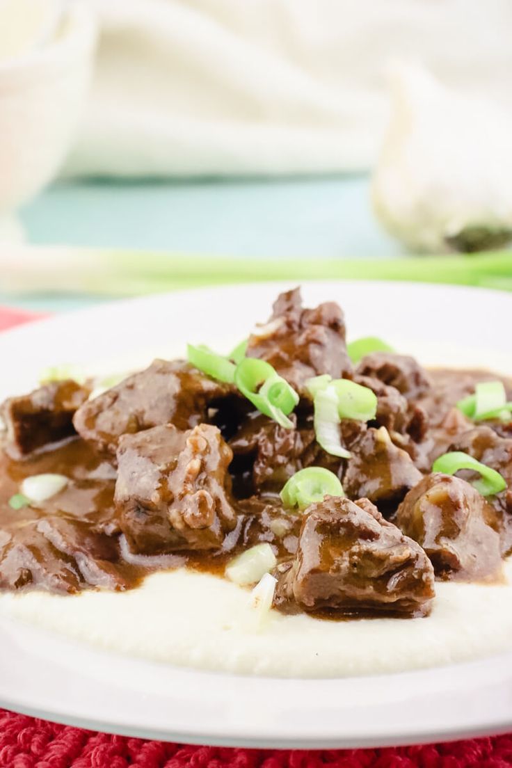 a close up of a plate of food with meat and gravy on it