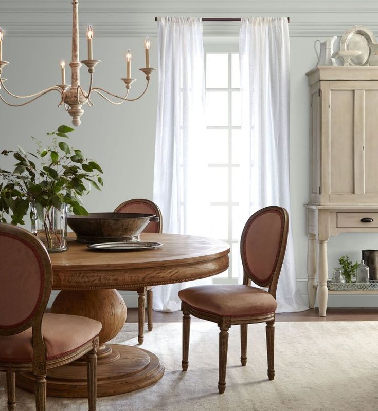 a dining room table and chairs in front of a window