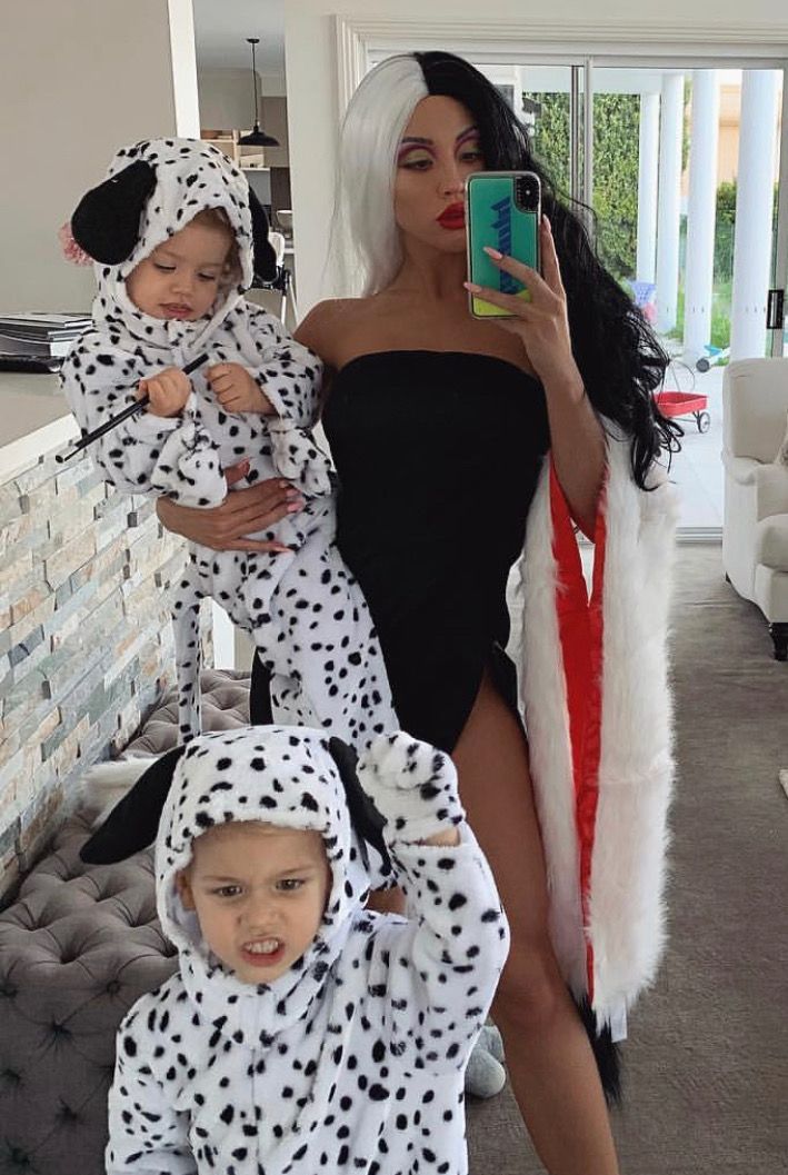 a woman and two children dressed up in dalmatian onesuits while taking a selfie