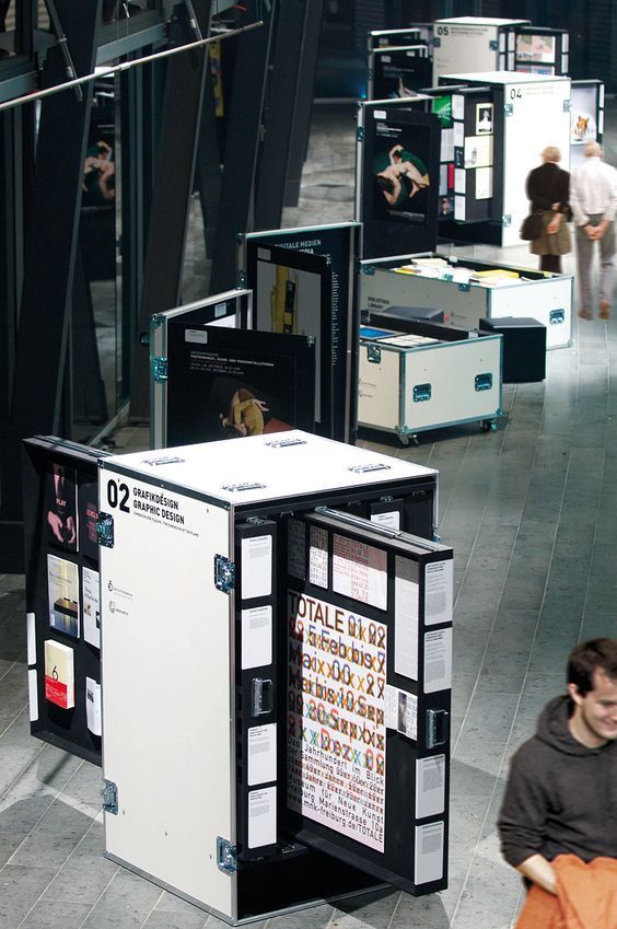 people are walking through an open area with many different types of mailboxs on display