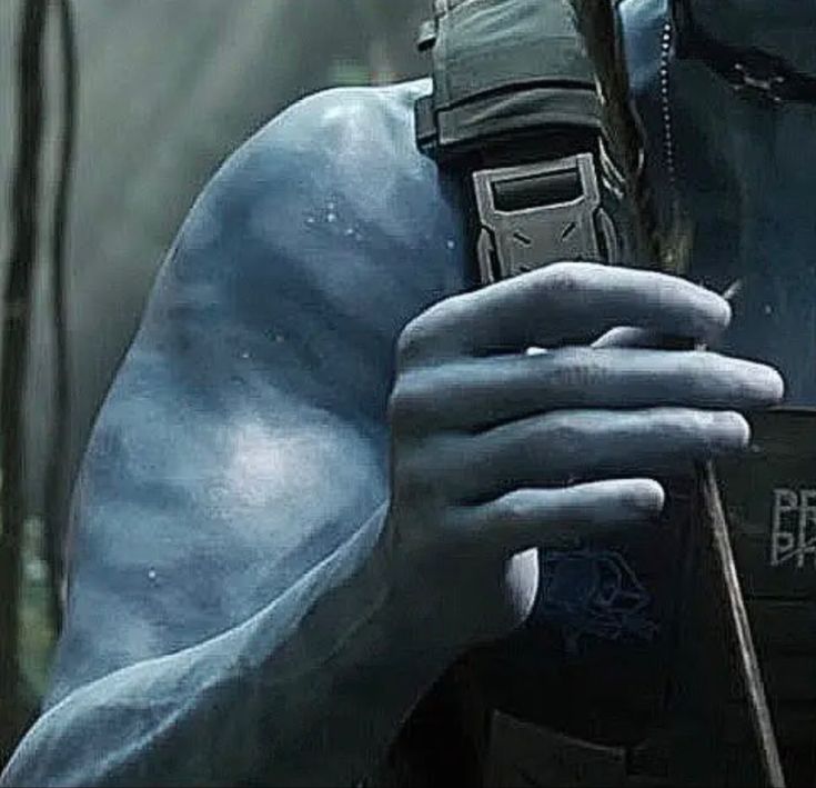 a close up of a person with blue paint on his face holding a cell phone