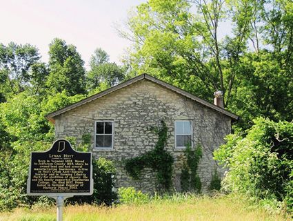 an old stone house with a plaque in front