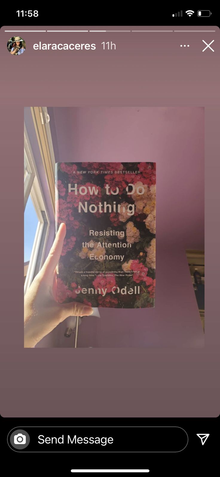 someone holding up a book in front of a window that says how to do nothing