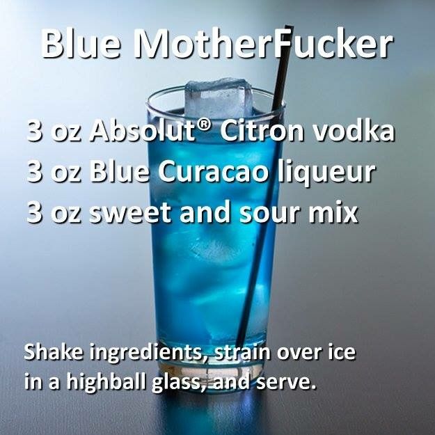 a tall glass filled with blue liquid on top of a table