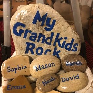 rocks with names on them sitting in front of a sign that says my grandkids rock