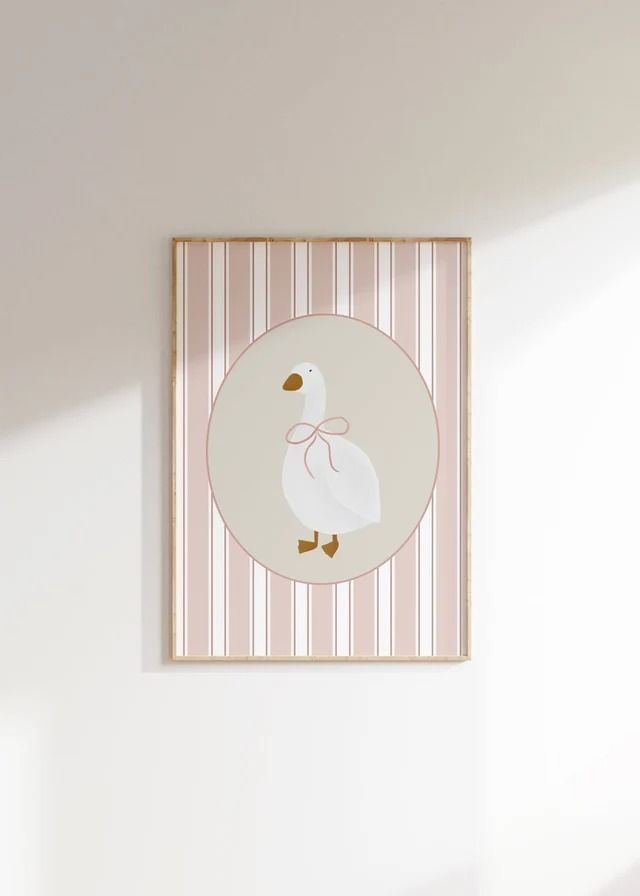 a white duck with a pink bow on it's head hanging from a wall