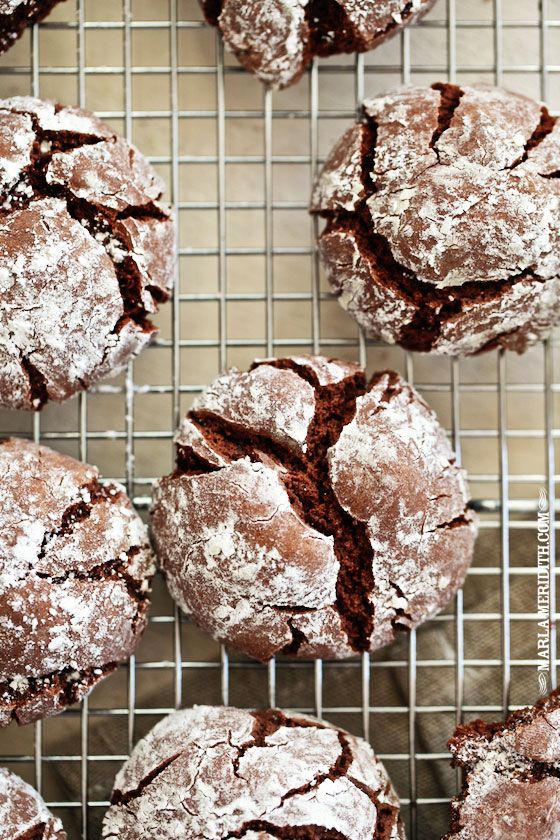 chocolate crinkle cookies on a cooling rack with powdered sugar sprinkled on top