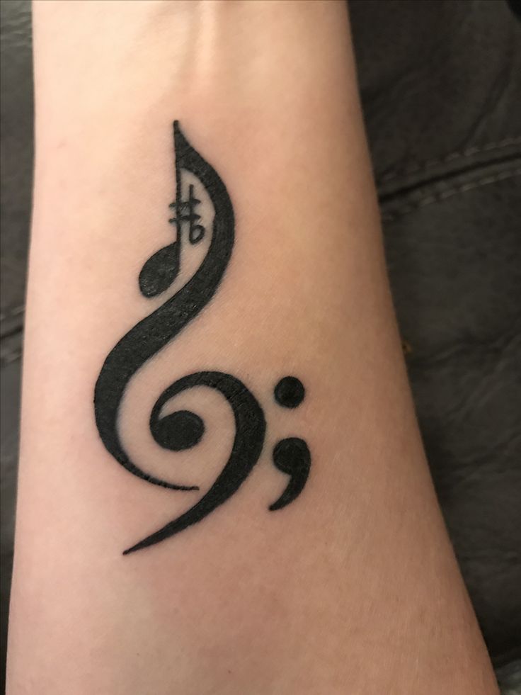 a black and white tattoo with musical notes on the side of someone's arm