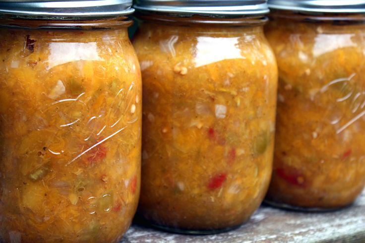 four jars filled with food sitting on top of a table