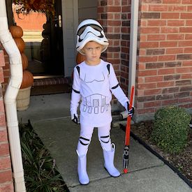 a young boy dressed up in a star wars costume