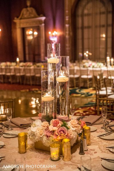 an elegant centerpiece with candles and flowers is displayed on the table at this wedding reception