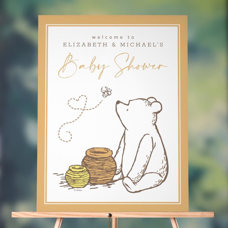 a baby shower sign with a bear sitting next to some pancakes on a easel