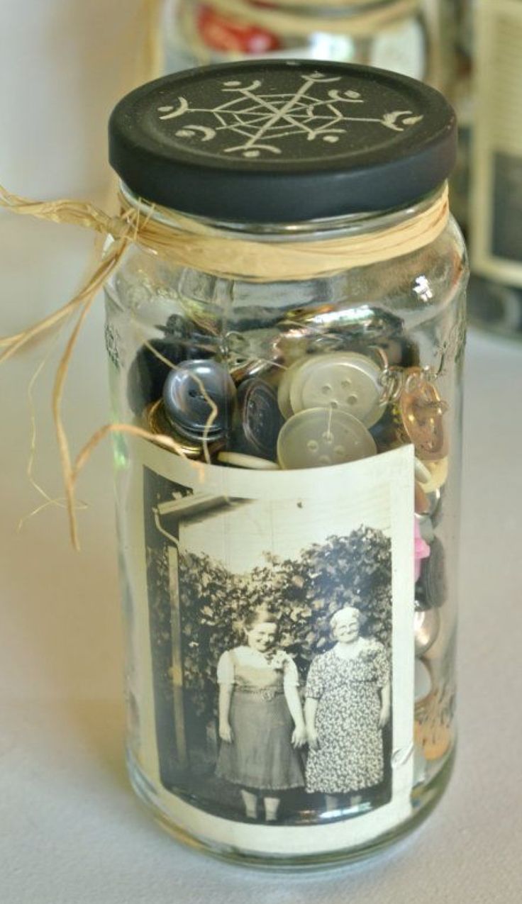 a jar filled with buttons sitting on top of a table next to two jars full of coins