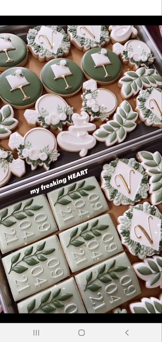 two trays filled with decorated cookies on top of each other