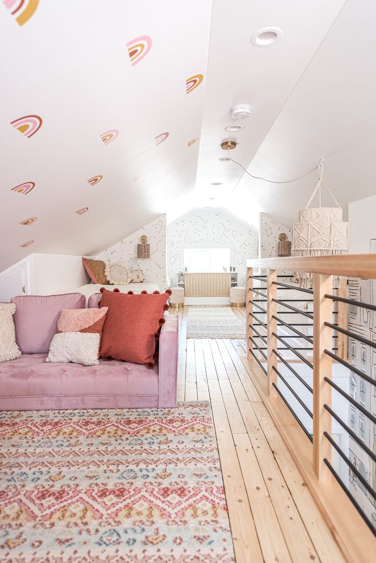 a living room filled with furniture next to a stair case covered in pillows and blankets