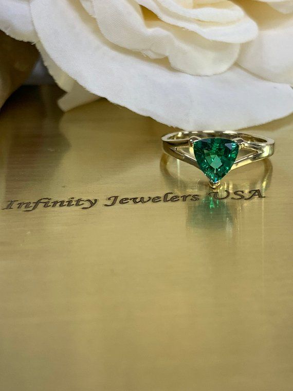 Trillion emerald engagement ring with split shank design in 14k yellow gold #5843 #LadiesRing #LabCreatedEmerald #HolidayGift #BirthdayGift #StatementRing #YellowGold #MothersDay #EngagementRing #AnniversaryGift #PromiseRing Heart-cut Emerald Ring For Formal Occasions, Trillion Cut Emerald Ring For Formal Occasions, Heart Cut Emerald Ring For Formal Occasions, Formal Heart Cut Emerald Ring, Classic Trillion Cut Emerald Ring For Formal Occasions, Elegant Gia Certified Trillion Cut Emerald Ring, Elegant Trillion Cut Gia Certified Emerald Ring, Classic Formal Trillion Cut Emerald Ring, Elegant Heart Cut Emerald Ring For Formal Occasions