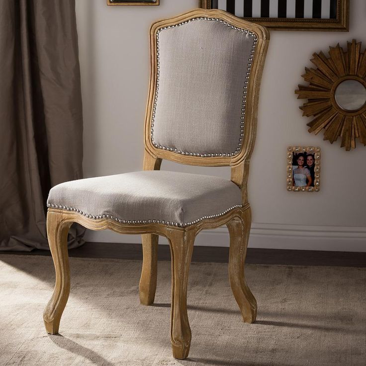 a wooden chair sitting in front of a mirror on top of a floor next to a window