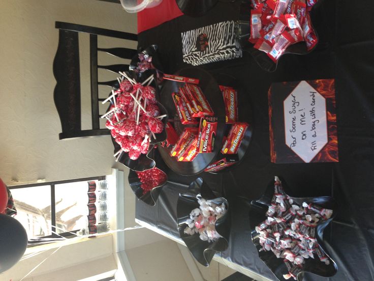 candy and candies are on display in front of a black table with red decorations