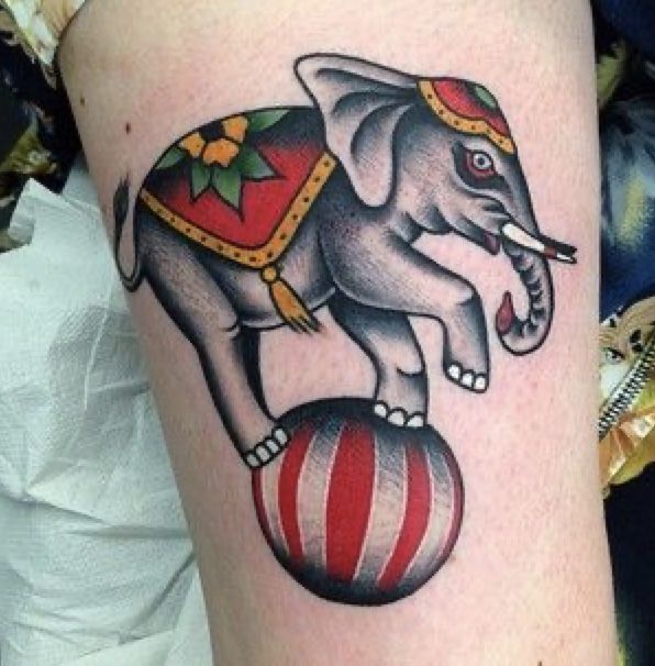 an elephant on top of a ball tattoo