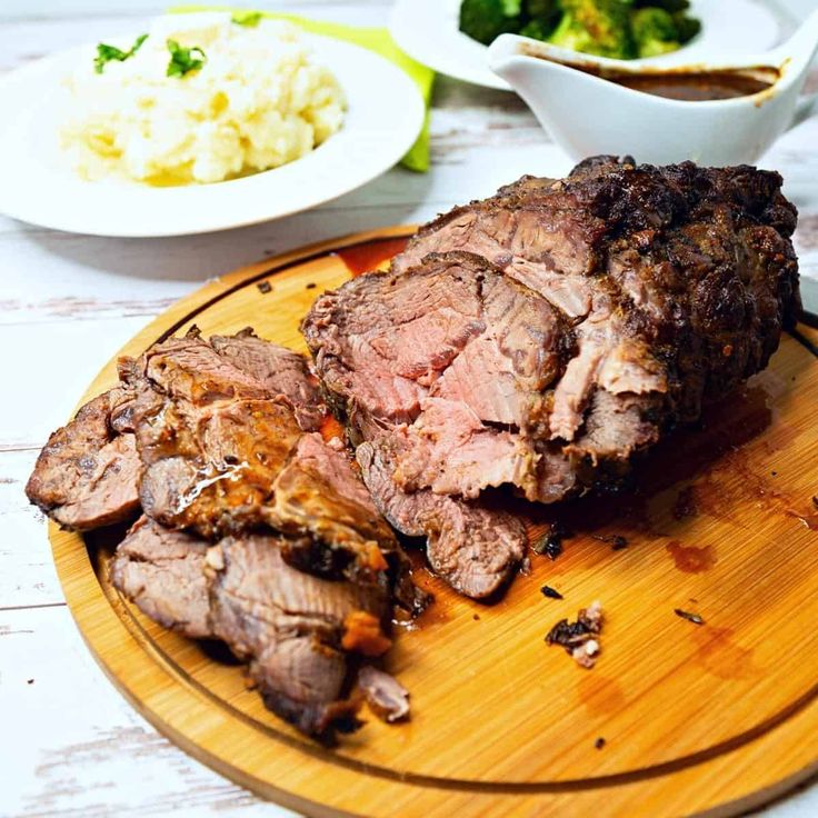 a wooden cutting board topped with meat and vegetables