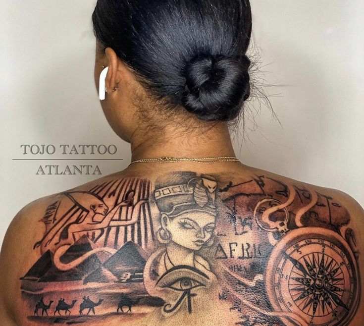 the back of a woman's upper body with tattoos on her shoulder and chest