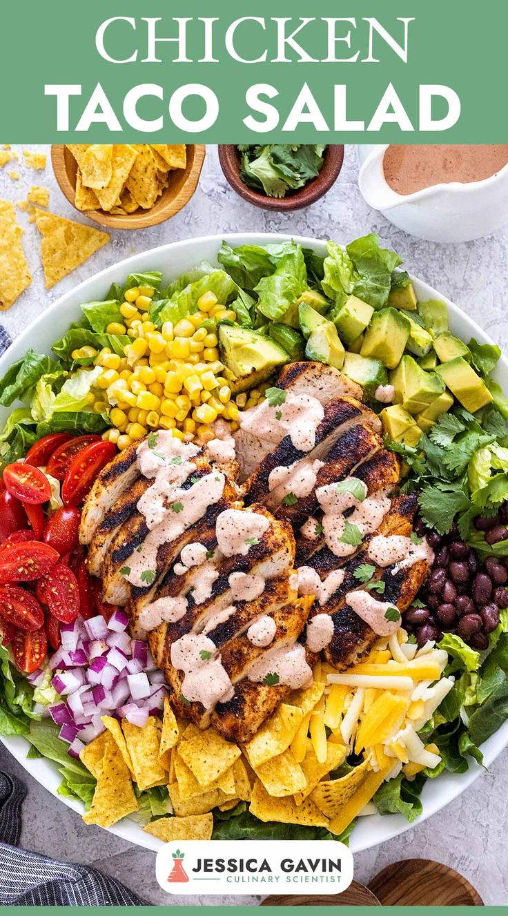 chicken taco salad in a white bowl with tortilla chips and avocado