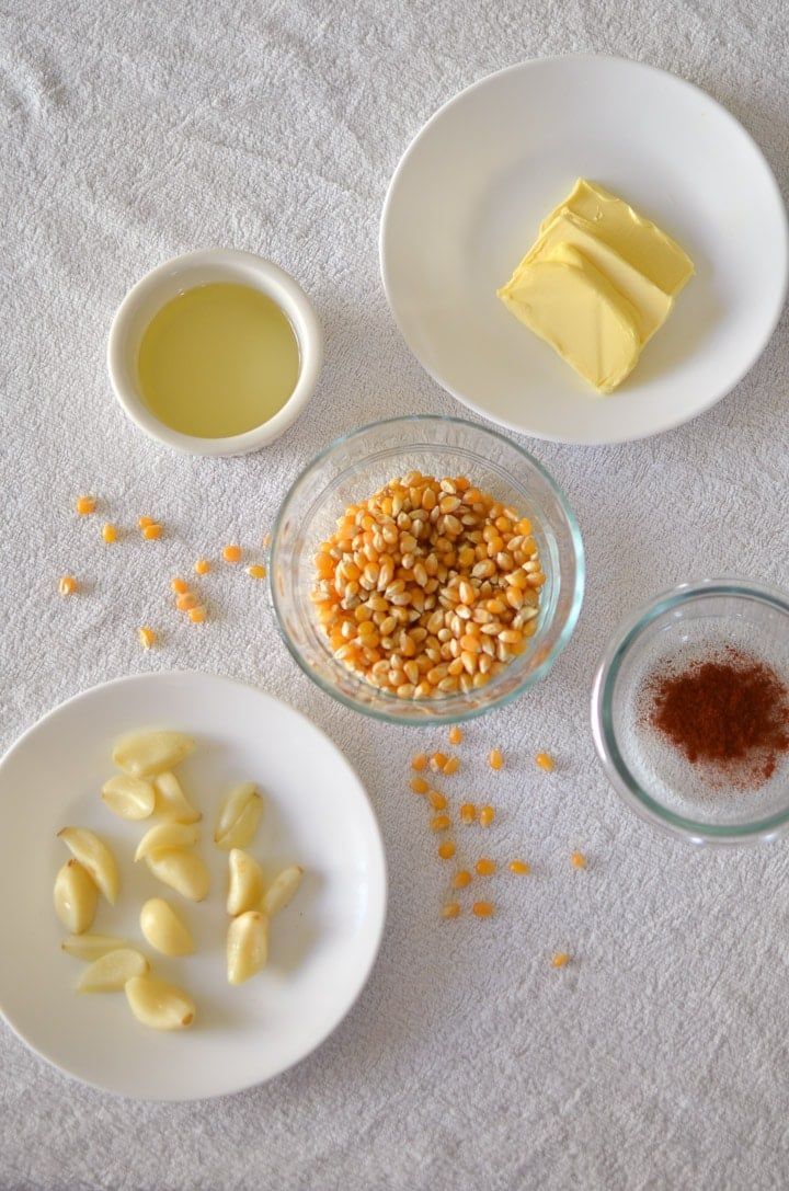 three bowls with different types of food in them on a white table cloth next to two cups