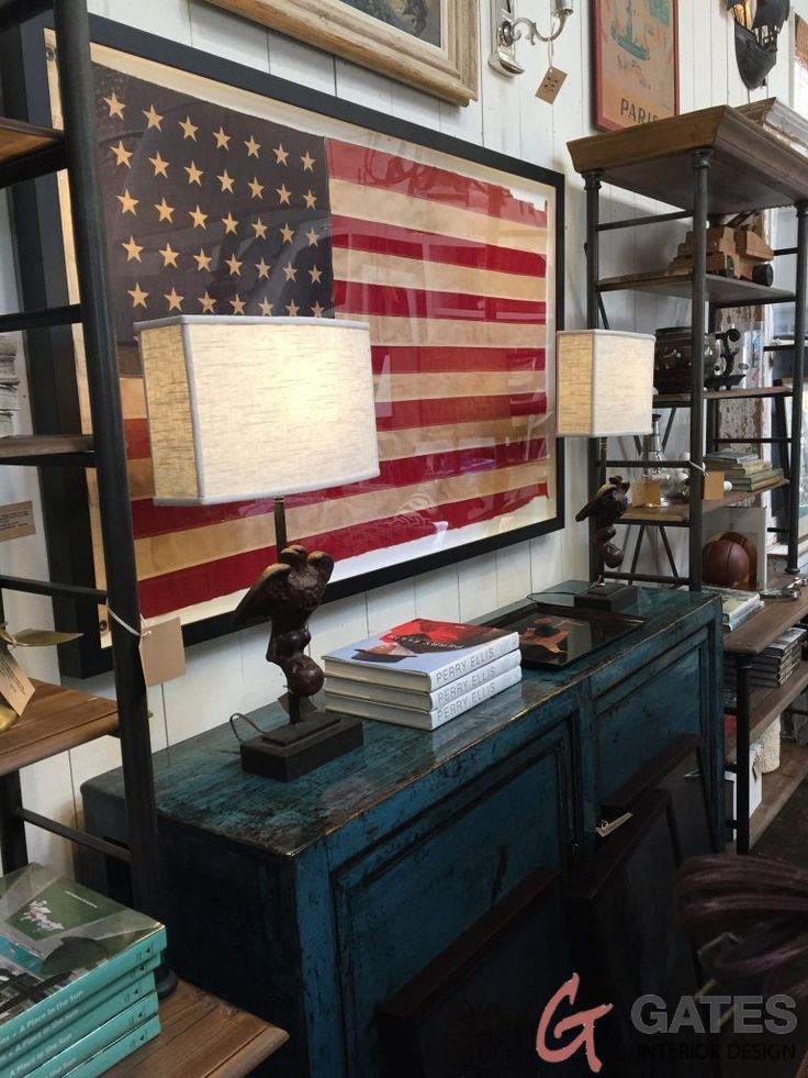 an american flag is hanging on the wall above a desk with books and other items