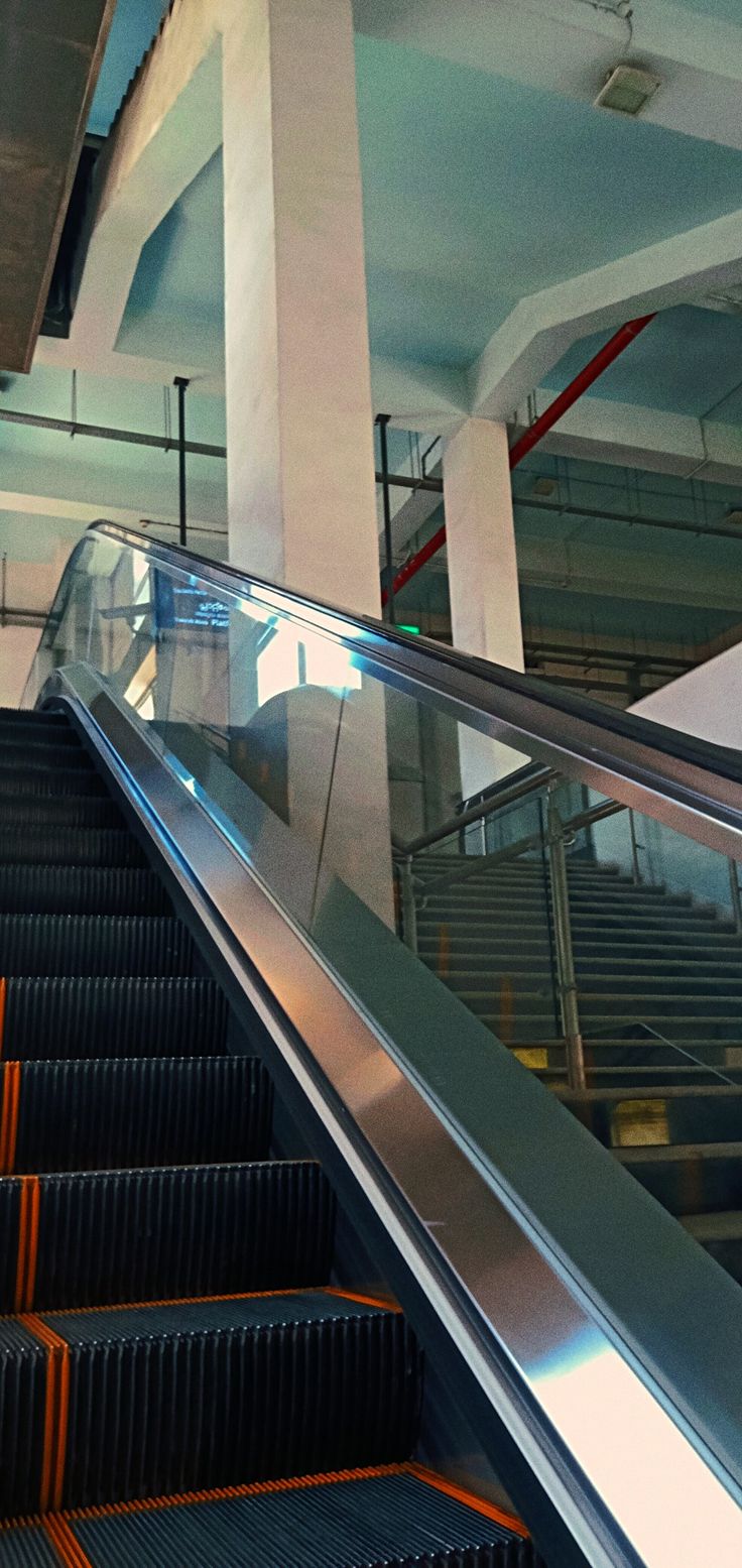 an escalator in a building with metal railings