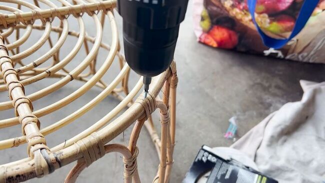 an electric drill is sitting on a wicker chair