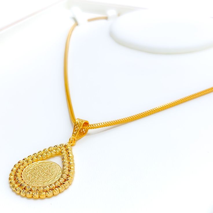 This stunning 22k gold pendant, weighing 7.8 grams, features an intricate engraved design that showcases exceptional craftsmanship. The yellow gold finish highlights the detailed engravings, making it a captivating accessory for any occasion. With a length of 1.75 inches, this pendant balances boldness and elegance perfectly. Ideal for those who appreciate detailed artistry and high-quality gold, this pendant can be paired with any chain of your choice. Its elaborate design and luxurious appeal make it a treasured addition to any jewelry collection, adding a touch of timeless beauty to any outfit. PRODUCT DETAILS Gold Purity(karat): 22k Gold Weight(grams): 7.8 Item Finish: Yellow Gold Pendant Length: 1.75" Chain: Not Included Traditional Necklace With Large Teardrop Pendant, 22k Gold Engraved Medallion Jewelry, Engraved 22k Gold Medallion Jewelry, Traditional Gold-plated Coin Pendant Necklace, 22k Gold Engraved Medallion Necklace, 22k Gold Medallion Necklace Engraved, Engraved 22k Gold Medallion Necklace, Traditional Hallmarked Oval Pendant Necklace, Traditional Gold Coin Jewelry