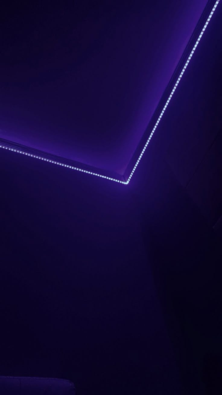 a bathroom with a purple light in the ceiling and a white toilet next to it