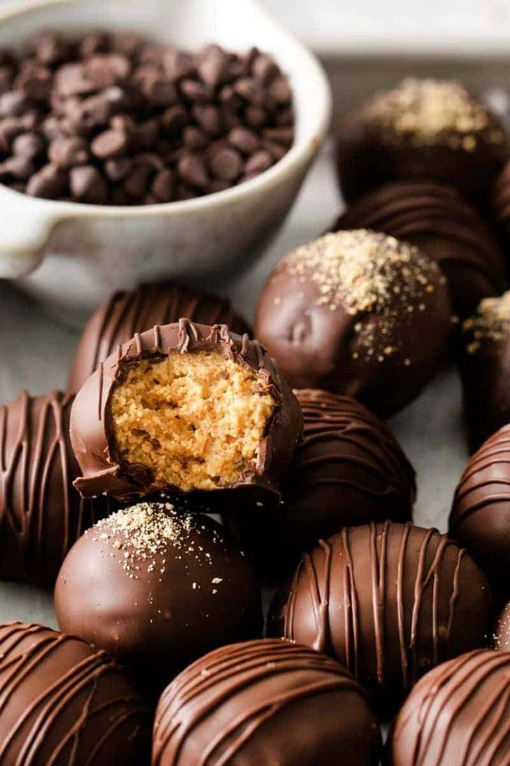 several chocolates are stacked on top of each other in front of a bowl of chocolate chips