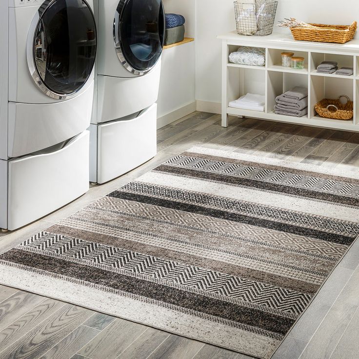 a washer and dryer sitting next to each other in a room with wooden floors