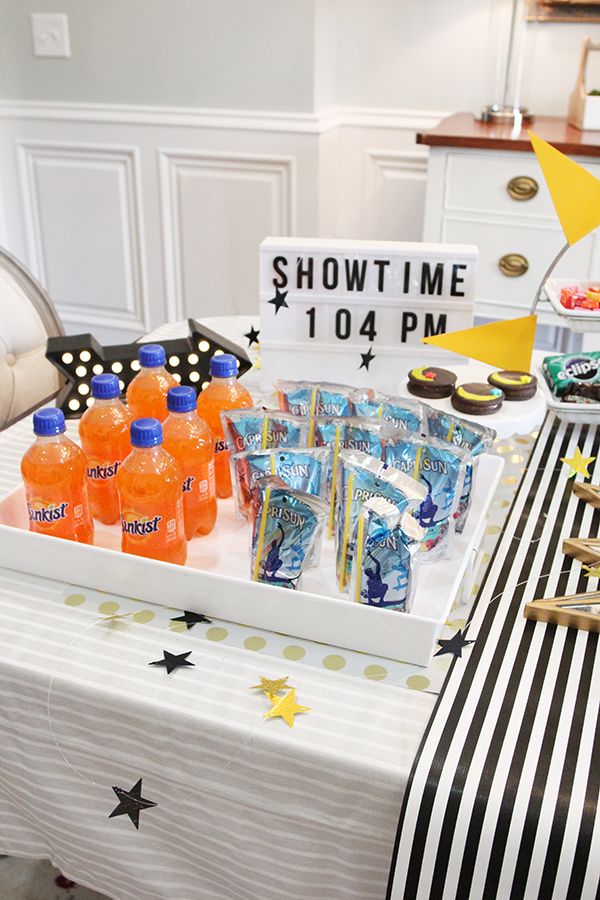 a party table with drinks and snacks for a show time birthday or baby's first birthday