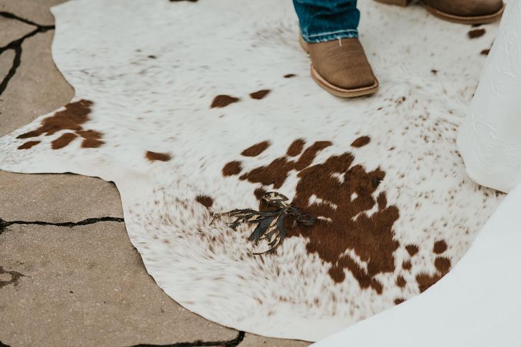 a person standing on top of a cowhide rug