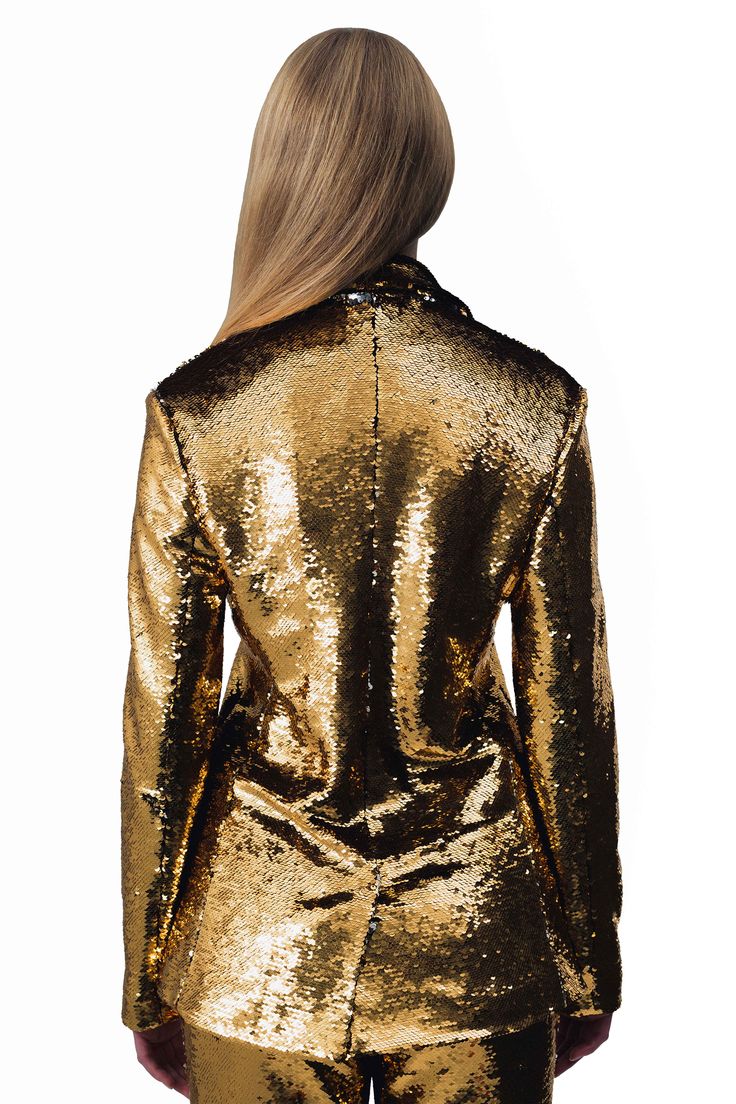 Goldie Sequin Blazer Key Features: Reversible gold and silver sequins Notch lapel and split tail Three gold buttons Three pockets Made in the USA Details: The Goldie Sequin Blazer features reversible gold and silver sequins with three gold buttons. Designed with a notch lapel, split tail, and three pockets, it effortlessly combines modern style and functionality. This stunning look is the perfect show stopper for any event. Content + Care: Dry Clean Only. Size & Fit: Model is wearing a size smal Luxury Evening Blazer With Gold Buttons, Glamorous Sequined Blazer For Formal Occasions, Elegant Metallic Blazer For Night Out, Gold Sequined Blazer For Fall, Fitted Party Blazer With Gold Buttons, Glamorous Formal Blazer With Sequins, Elegant Party Blazer With Gold Buttons, Chic Party Blazer With Gold Buttons, Party Blazer With Gold Buttons And Long Sleeves