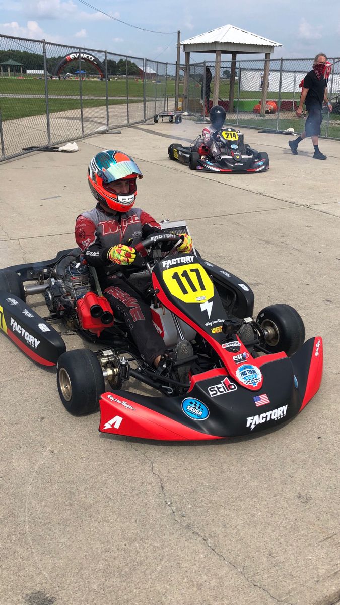 a young man driving a go kart on top of cement