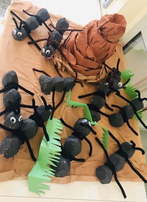 some black and green decorations on top of a brown paper bag in the shape of bugs