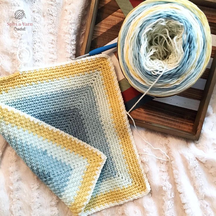 two skeins of yarn sitting on top of a wooden tray