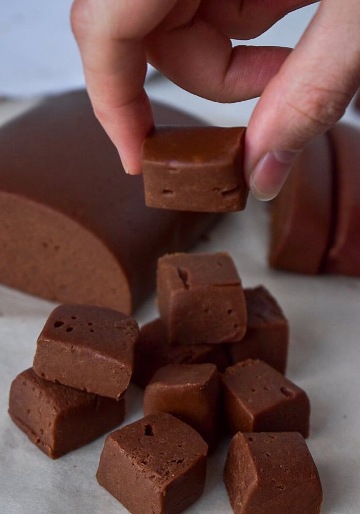 someone is picking up pieces of chocolate from the table